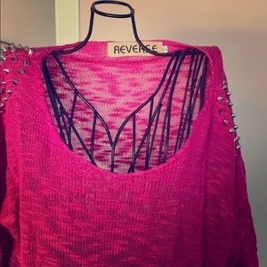 Pink sweater with silver studs.